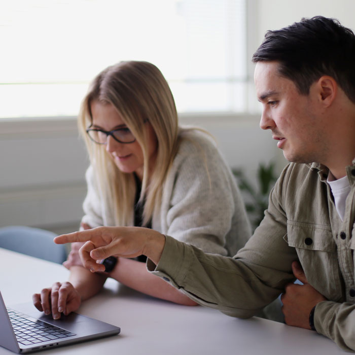 CleanManager-Kollegen sitzen gemeinsam am Bildschirm und arbeiten an einer Aufgabe.